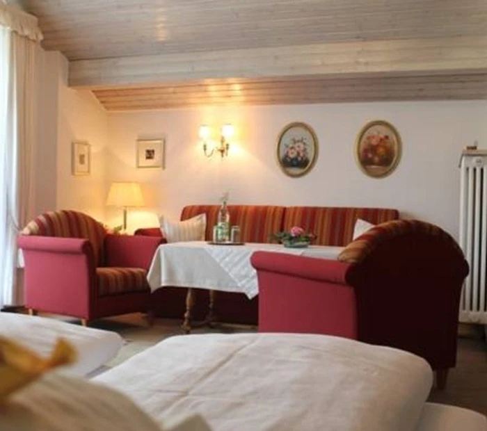 Doppelzimmer Komfort mit Blick vom Bett zur Sofaecke mit Tisch