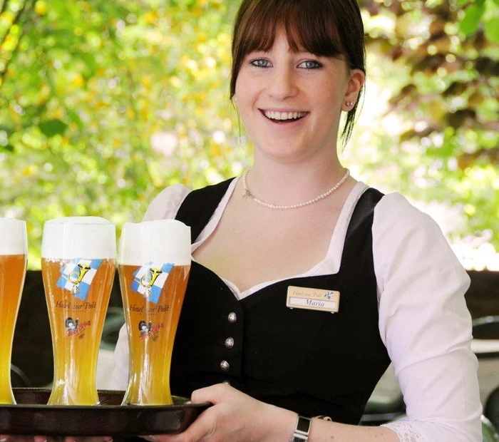 unsere Bedienung Maria trägt Weißbier auf dem Tablett