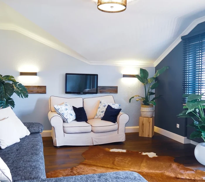 Sofalandschaft mit grauem Sofa und Grünpflanzen im Appartement 2