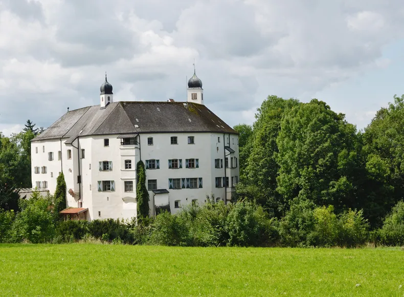 Von einer Grünfläche aus blicken Sie auf das Schloss Amerang im Chiemgau Von einer Grünfläche aus blicken Sie auf das Schloss Amerang im Chiemgau