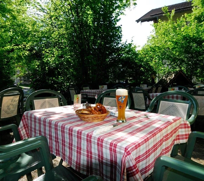 Gastgarten mit Weißbier und Brezen auf dem Tisch