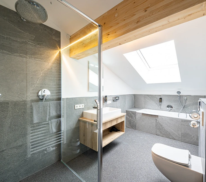 Ein modernes Badezimmer mit Dusche, Badewanne und WC im Berghotel Adersberg