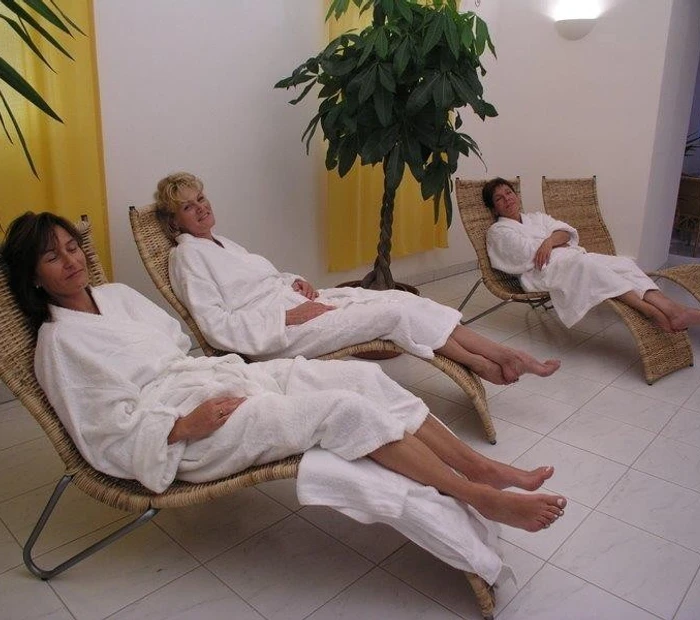 drei Gäste entspannen auf Ruheliegen im Wellnessbereich