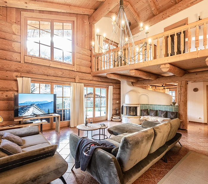 Wohnraum mit Kamin und Galerie Naturstamm-Alpenchalet