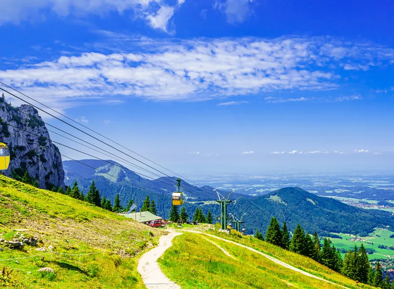 Sie stehen auf der Kampenwand und blicken auf die Seilbahn. Sie stehen auf der Kampenwand und blicken auf die Seilbahn.
