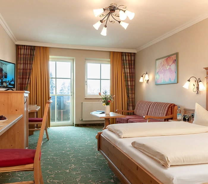 Doppelzimmer mit Balkon, Schreibtisch, Fernseher und Sitzecke