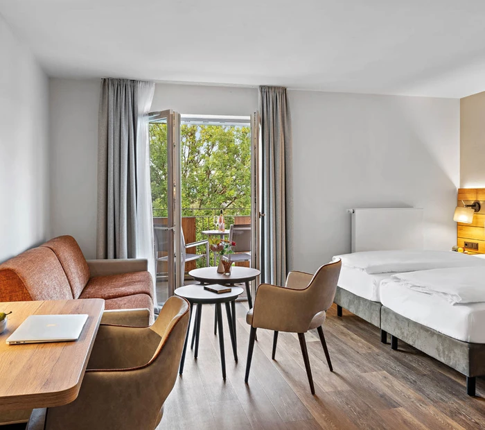 Balkonzimmer mit Doppelbett und Sofaecke