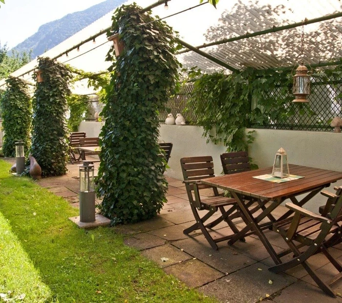 Überdachte Gartenterrasse mit gemütlich Holzsitzgruppen