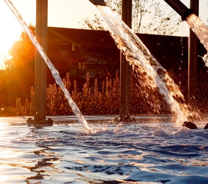 Chiemgau Thermen Schwallduschen im Aussenbereich bei Sonnenuntergang 