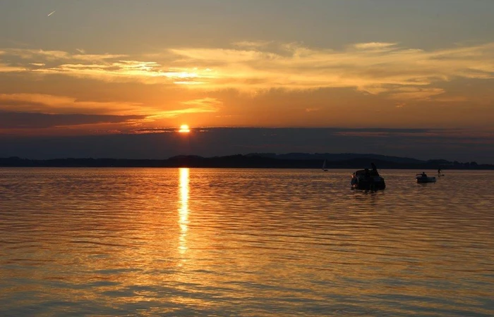 Auf den Bild ist ein Sonnenuntergang mit Blick auf den Chiemsee zu sehen.