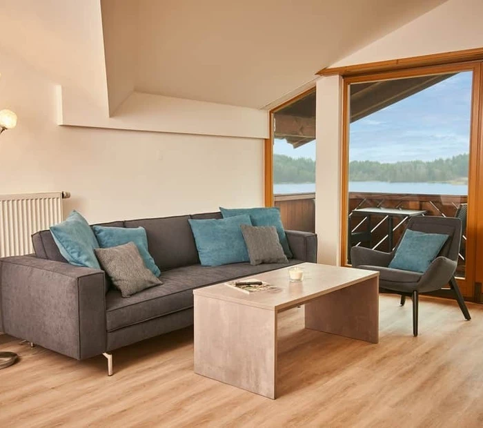 Sofaecke am großen Fenster mit Blick zum See