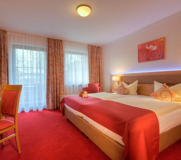 Doppelbett im Zimmer Parksee mit rotem Teppichboden