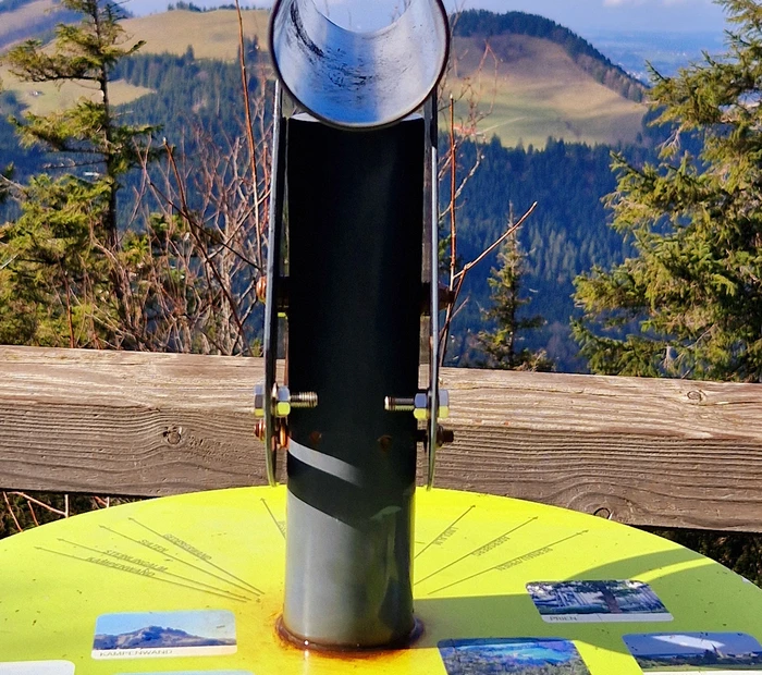 Einfaches Fernrohr mit Infotafel welche Alm und welcher Berg zu sehen ist