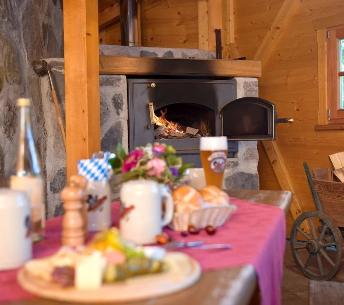 Brotbackofen und gedeckter Tisch mit Brotzeit im Gartenhaus