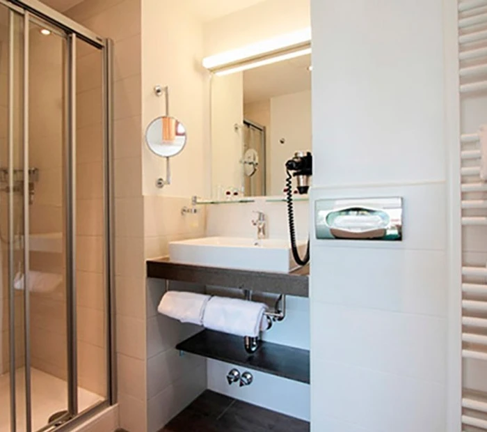 Badezimmer im Komfort-Doppelzimmer mit Waschtisch, Duschkabine und Wandheizung 