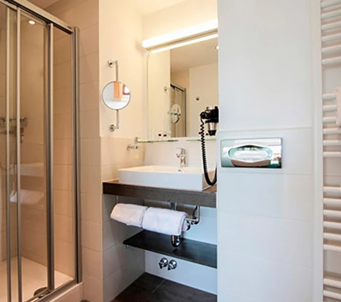 Badezimmer im Komfort-Doppelzimmer mit Waschtisch, Duschkabine und Wandheizung