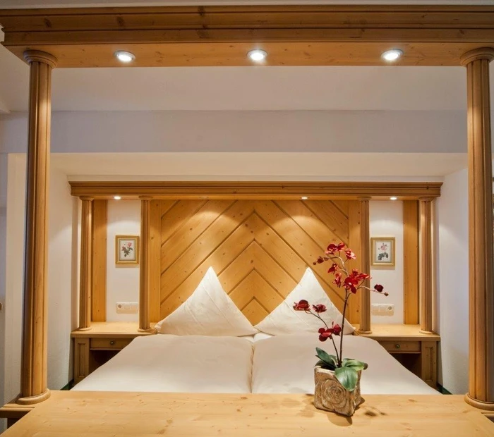 Doppelbett mit Säulen aus Holz im Doppelzimmer