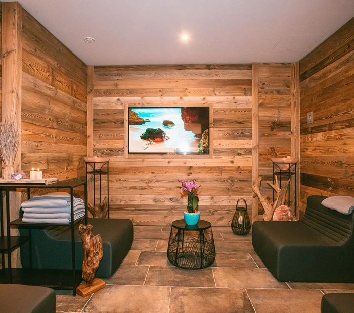 Wellnessbereich mit Holz, schwarzen Sofas und Deko im Yachthotels Chiemsee