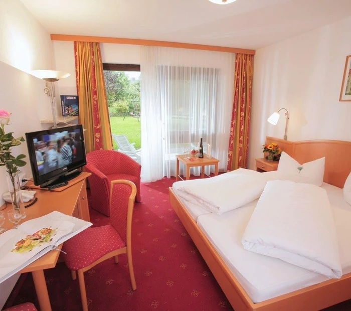 Schlafzimmer der Suite mit direktem Gartenzugang und kleinem Schreibtisch