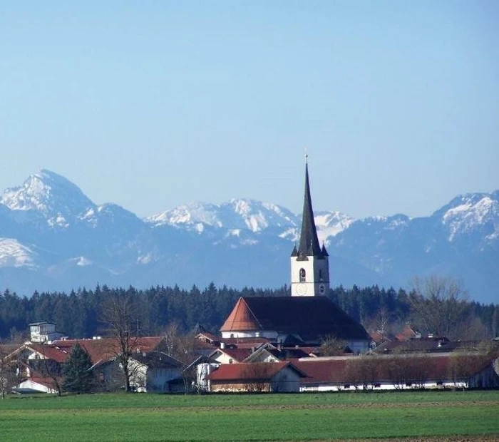 Blick auf Halfing mit schneebedeckten Bergen im Hintergrund