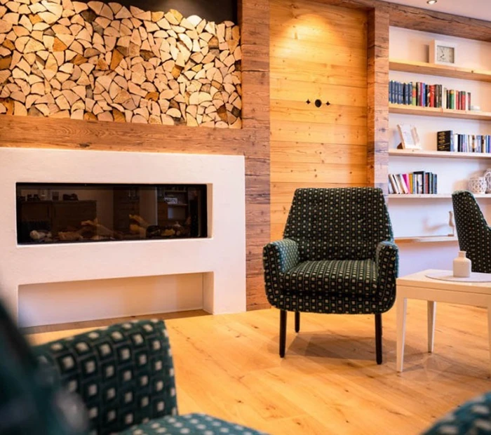 In der Lobby ist eine Sitzecke mit Kamin im SeeHotel Wassermann Chiemsee