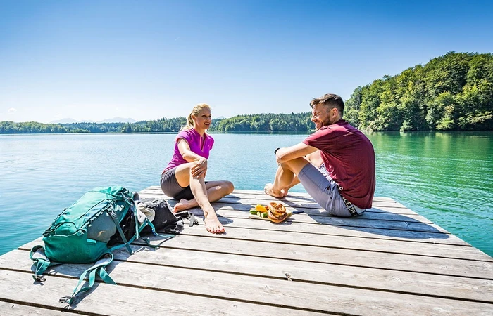 Paar sitzt am Steg an der Eggstätt Hemhofer Seenplatte