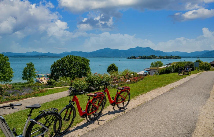 3 Fahrräder stehen auf einer Anhöhe mit Blick auf den Chiemsee.