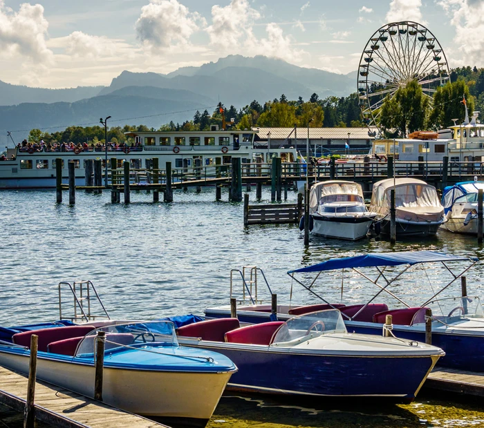 Blick auf den Hafen von Prien am Chiemsee mit Schiffen und Riesenrad.