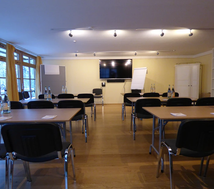 Seminarraum mit Flatscreen, Whiteboard und Flipchart 